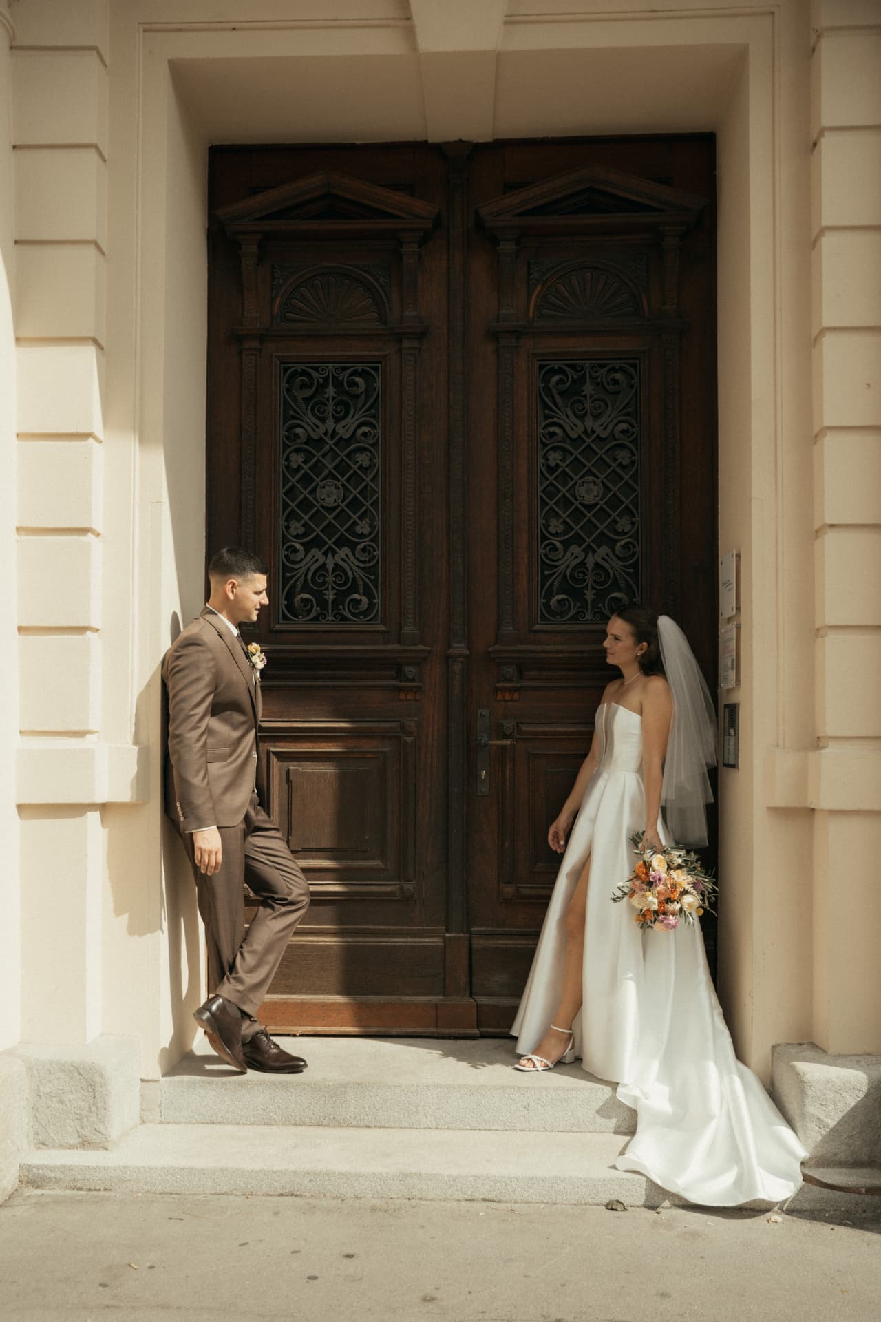 Braut und Bräutigam vor historischem Holzportal – editorial Hochzeitsfotografie Augsburg