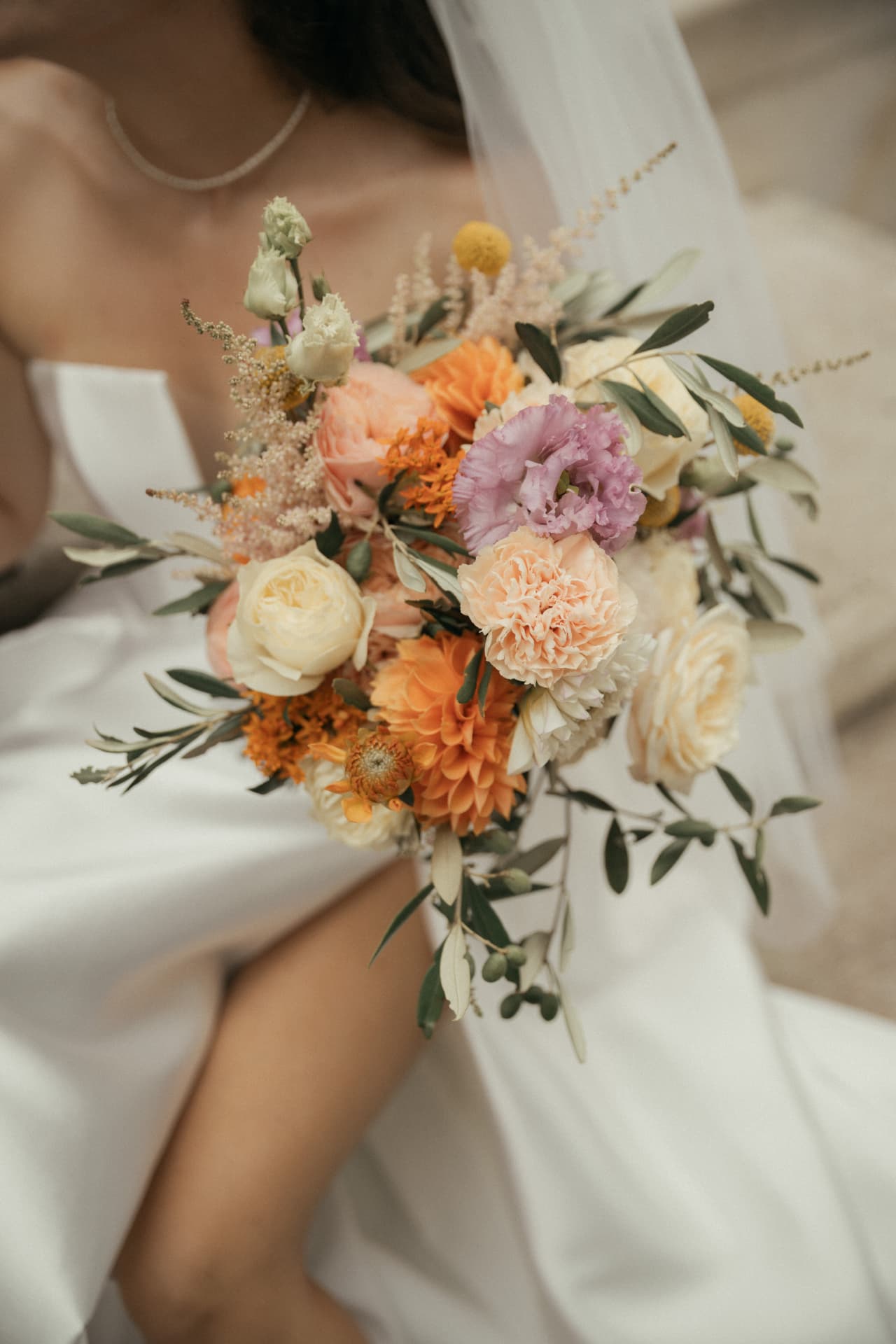 Bunter Brautstrauß auf dem Brautkleid – Hochzeitsdetails Augsburg