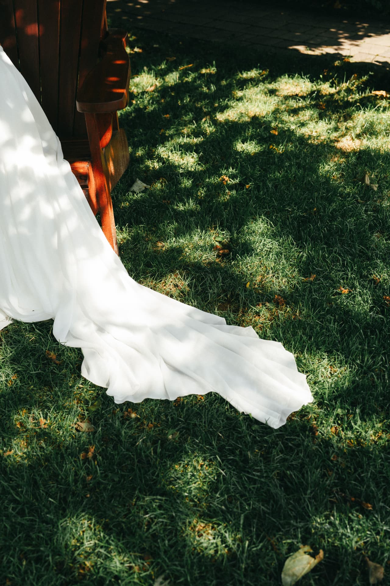 Schleppe des Brautkleids auf sonniger Wiese – Hochzeitsdetails Augsburg