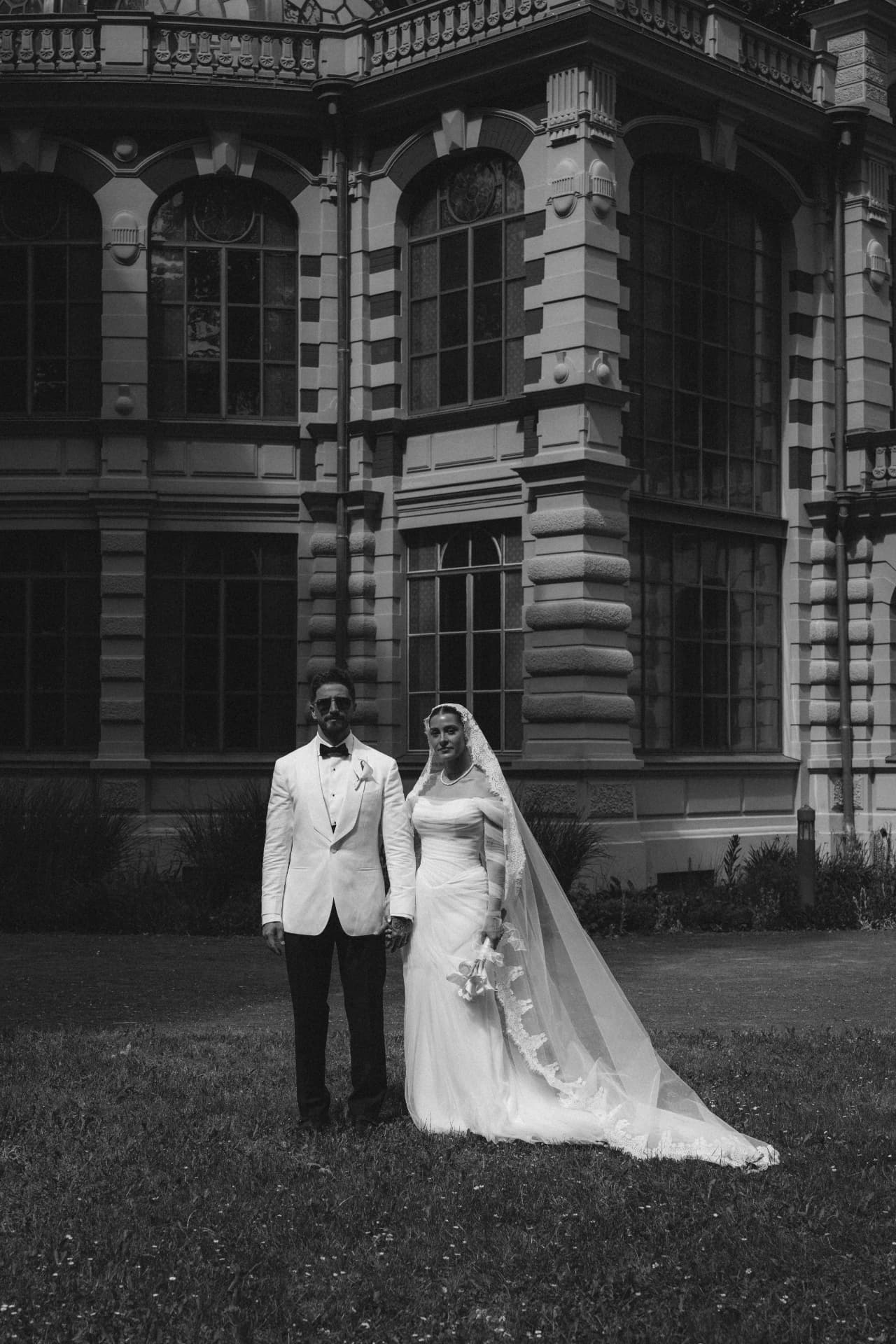 Brautpaar in Schwarzweiß vor historischer Villa – editorial Hochzeitsfotograf Bayern