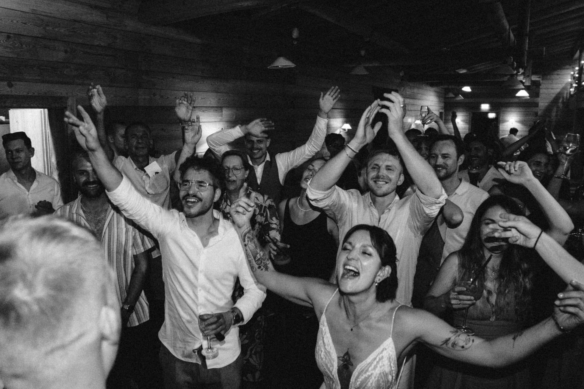 Feiernde Hochzeitsgäste auf der Tanzfläche in Schwarzweiß – Hochzeitsreportage Allgäu
