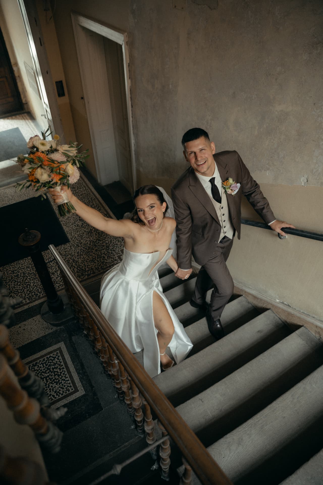 Brautpaar jubelt auf der Treppe im Standesamt – Hochzeitsfotograf Augsburg