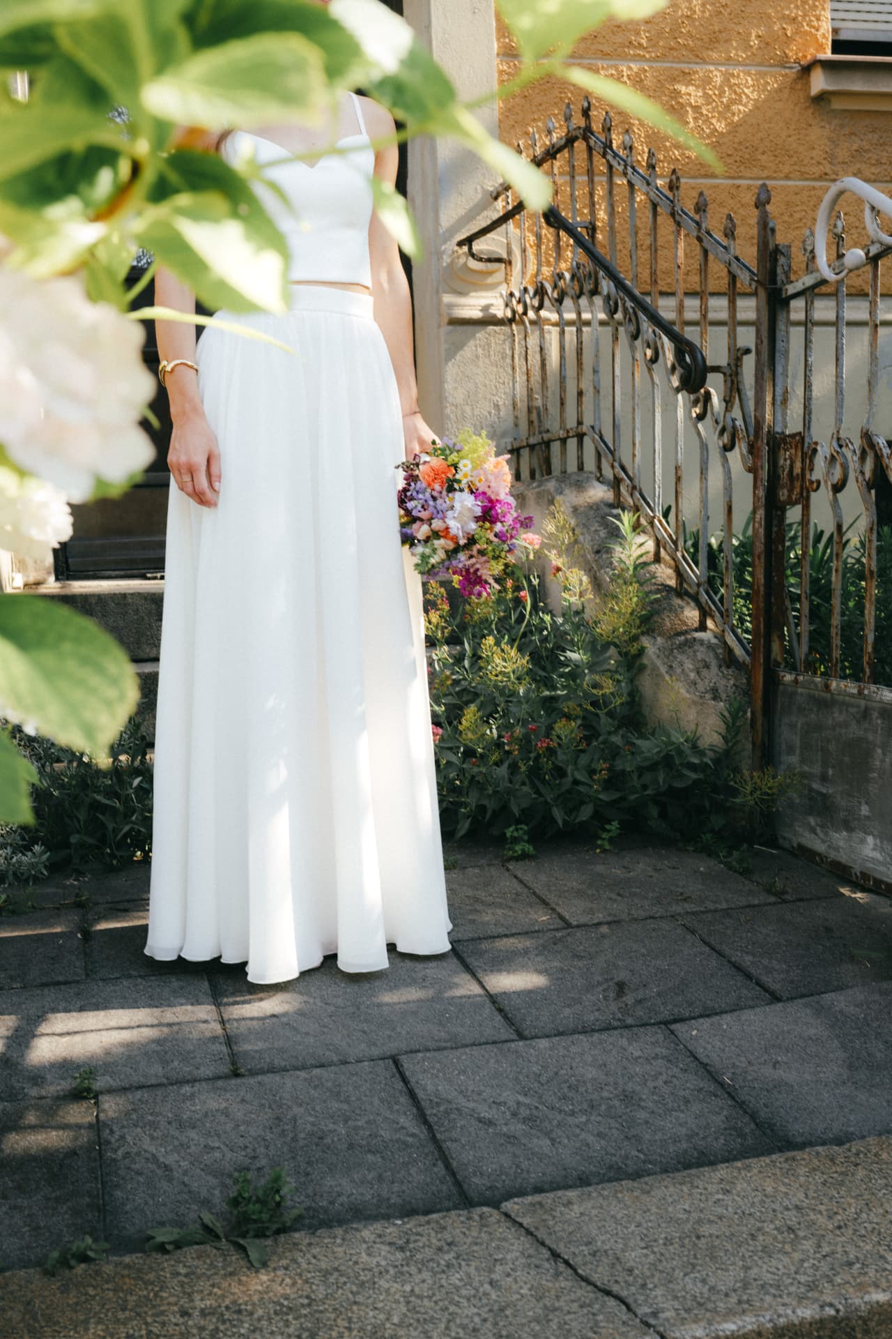 Braut in weißem Kleid mit buntem Brautstrauß – Hochzeitsdetail Augsburg